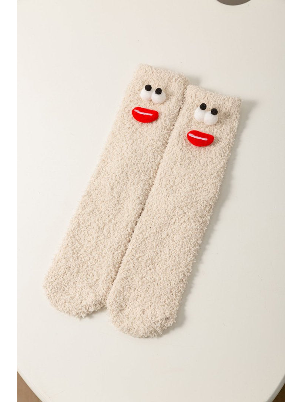 Beige fuzzy socks with raised red-lip face appliques