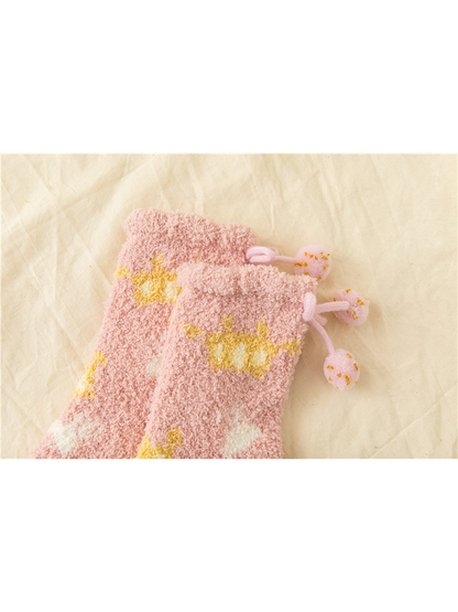 Close-up of Light Pink fuzzy socks with fold-over cuffs and pom-pom ties