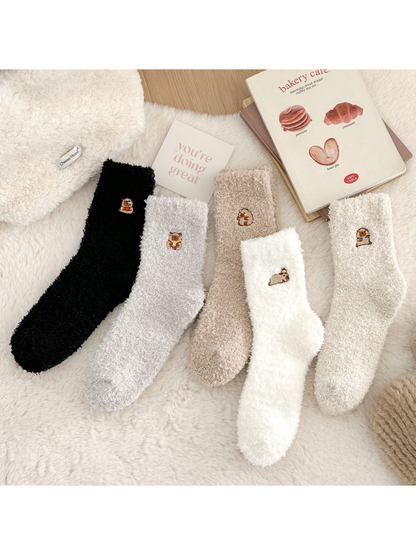 Gray, black, white, khaki, and ivory fuzzy crew socks with embroidered animal motifs
