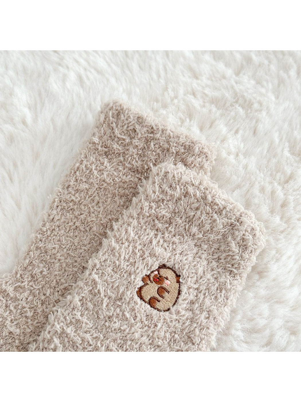 Close-up of a small embroidered animal motif on fuzzy khaki socks
