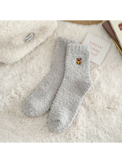 Gray fuzzy crew socks with a small embroidered animal motif
