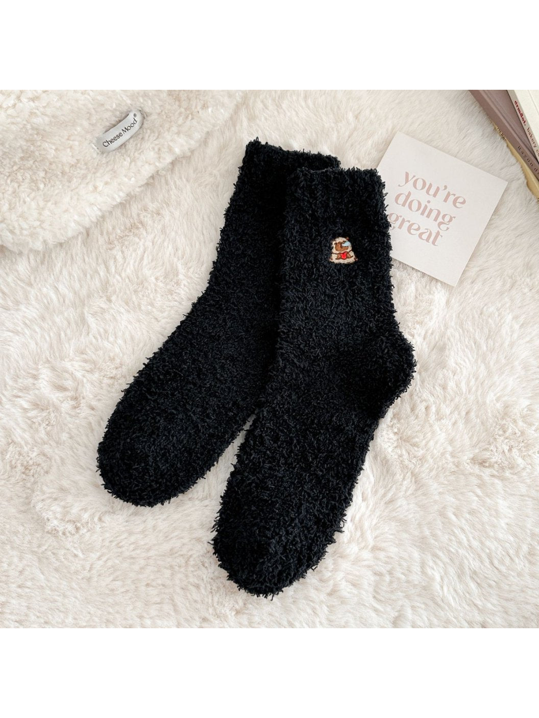 Black fuzzy crew socks with a small embroidered animal motif