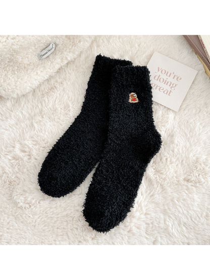 Black fuzzy crew socks with a small embroidered animal motif