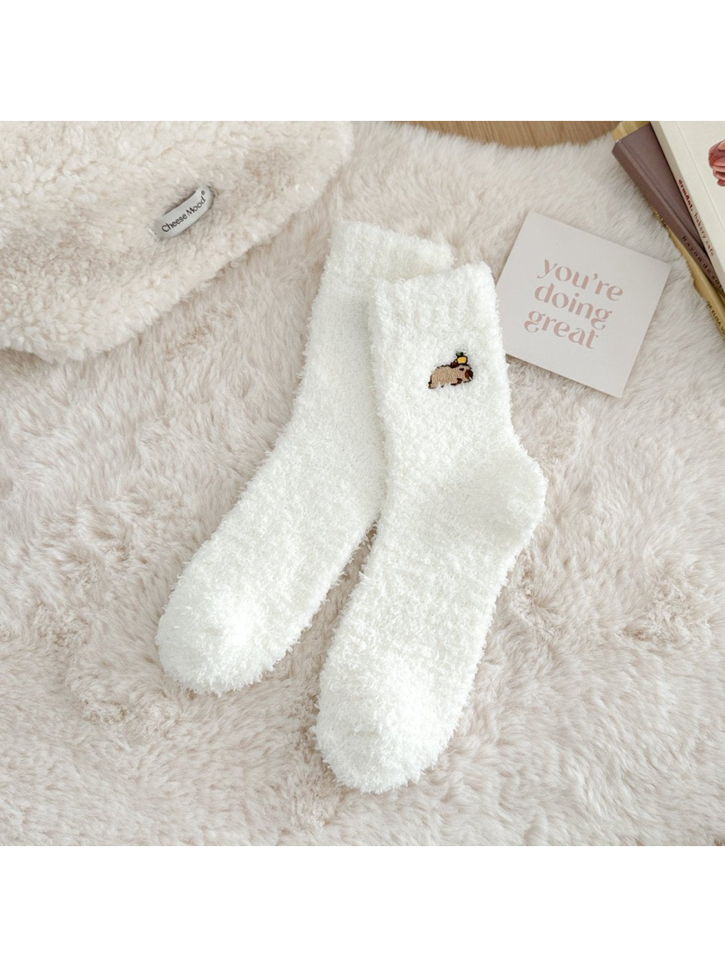 White fuzzy crew socks with a small embroidered animal motif