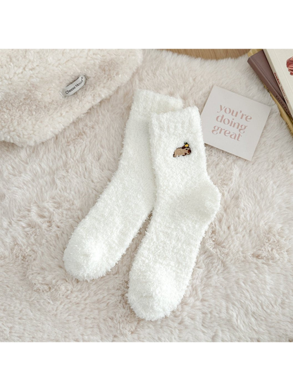 White fuzzy crew socks with a small embroidered animal motif