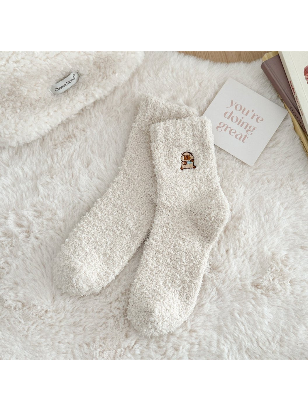 Ivory fuzzy crew socks with a small embroidered animal motif
