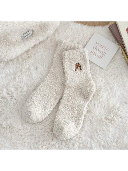 Ivory fuzzy crew socks with a small embroidered animal motif