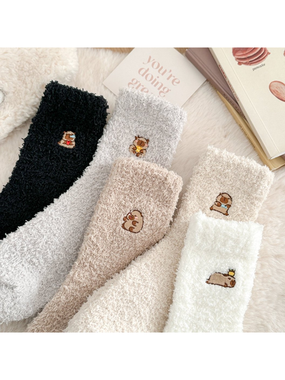 Close-up of five fuzzy sock colors with different embroidered animal motifs