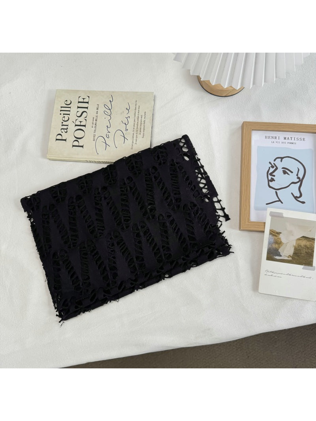 Black openwork scarf folded on a neutral tabletop