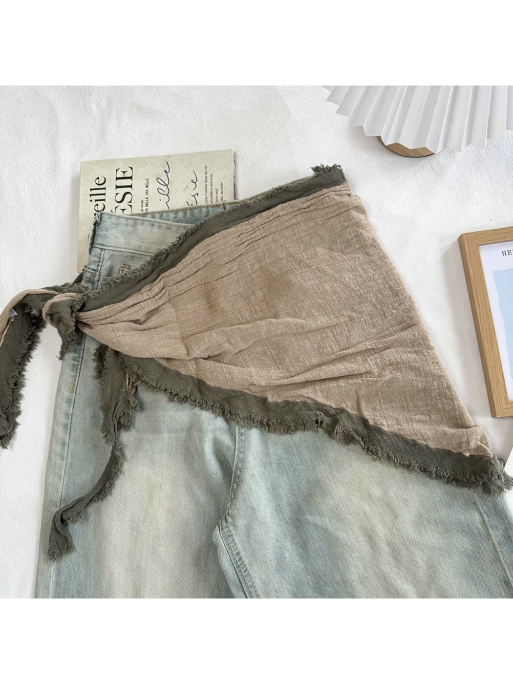 Beige Green triangle scarf tied over light-wash jeans