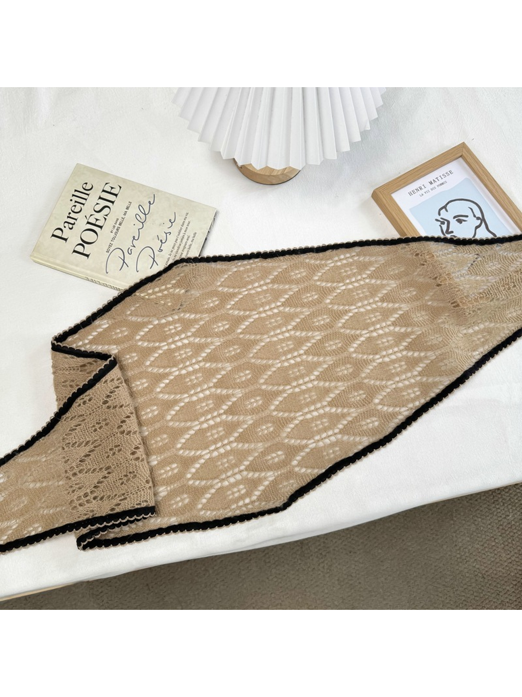 Camel openwork scarf laid flat to show its long tapered shape