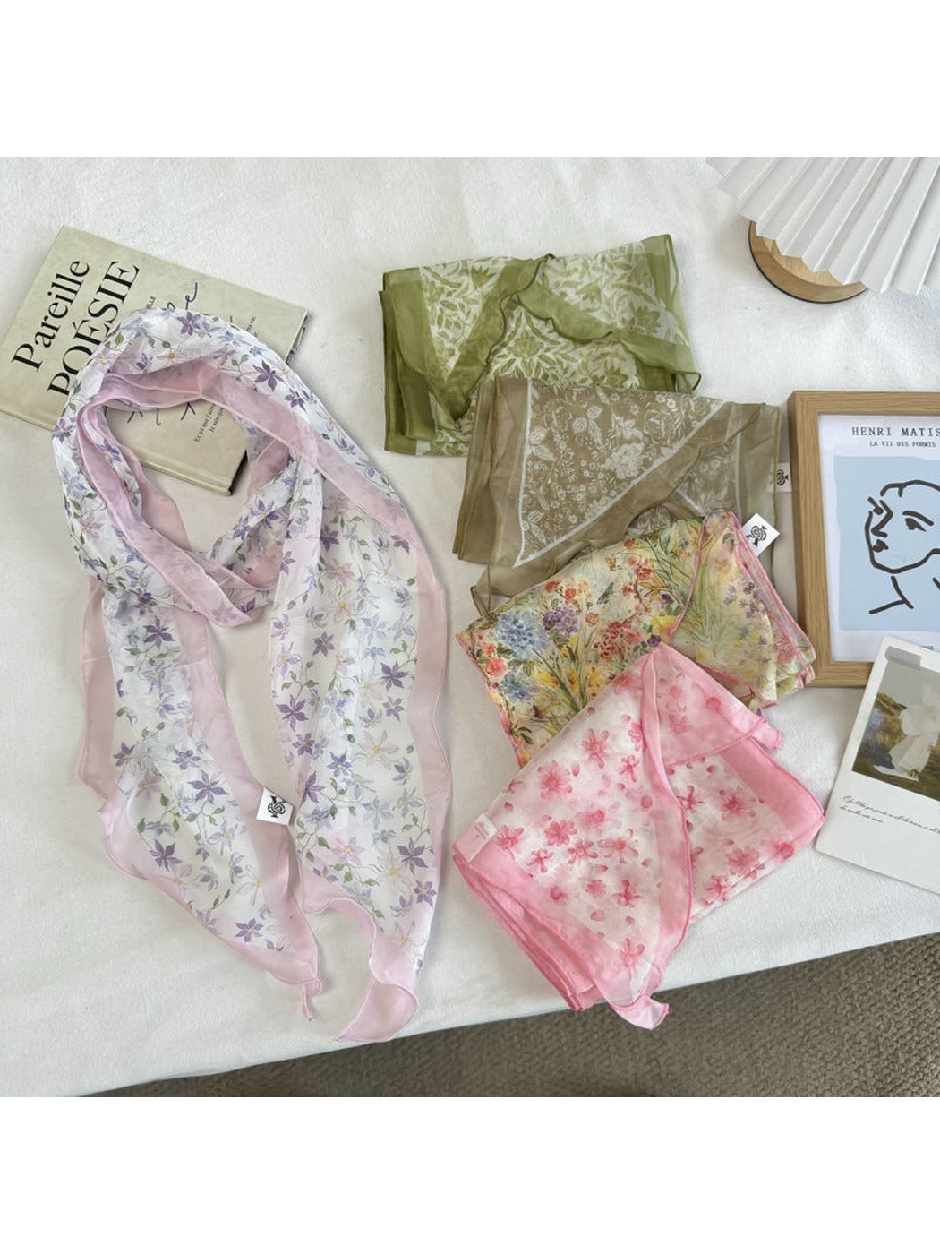 Five floral scarf styles arranged together on a neutral surface