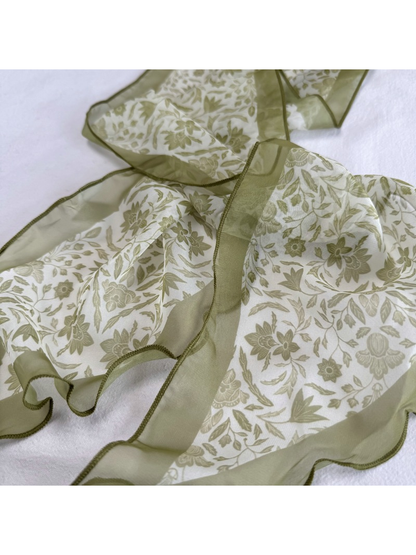 Close-up of olive botanical print, translucent border, and stitched edge