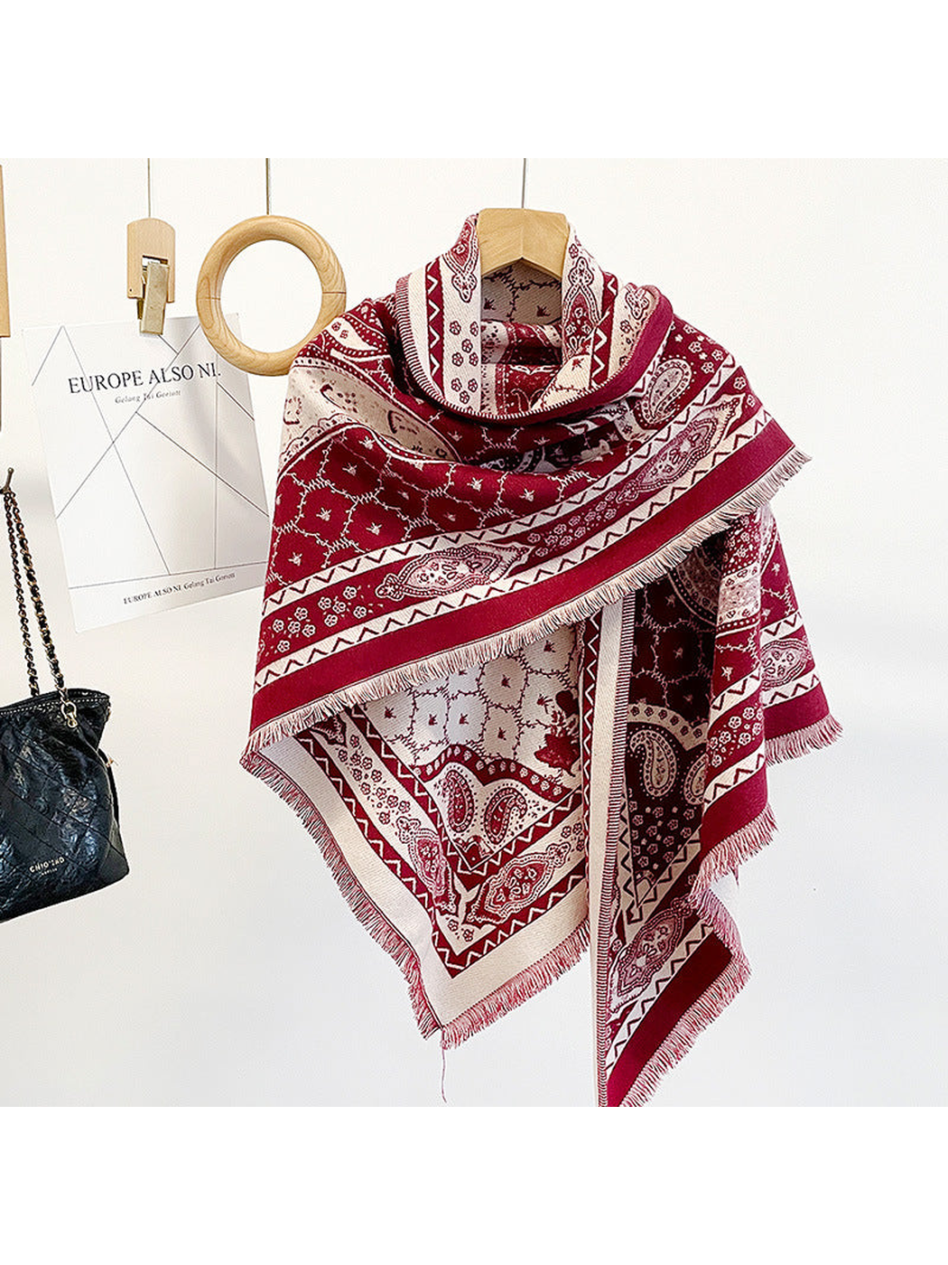 Red paisley triangle scarf draped on a hanger