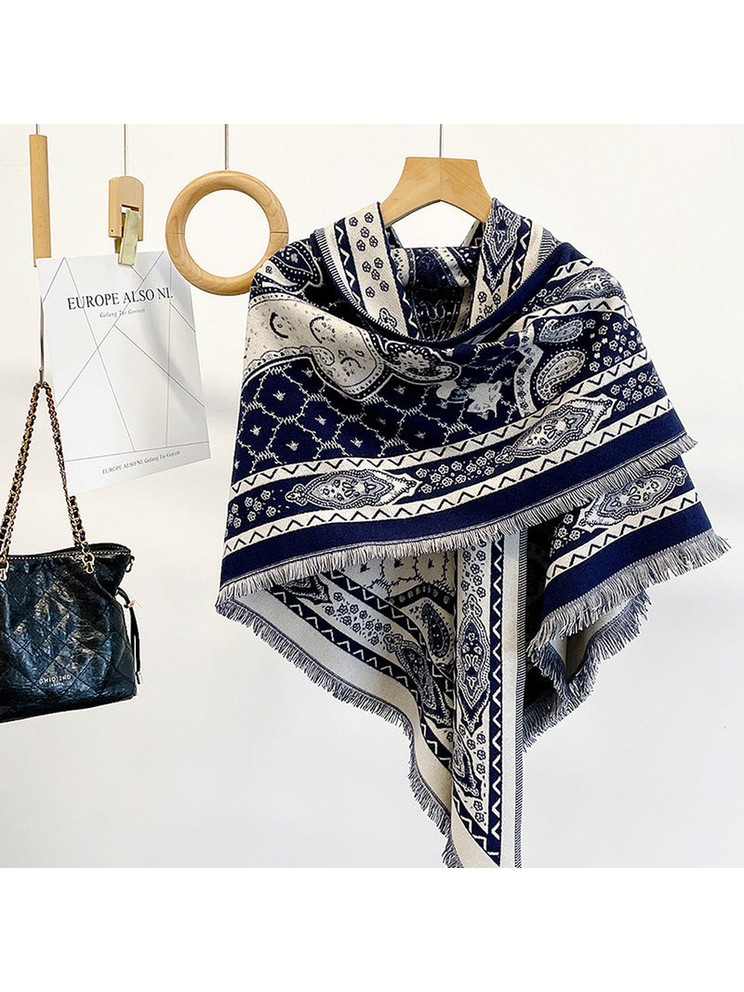 Navy paisley triangle scarf draped on a hanger