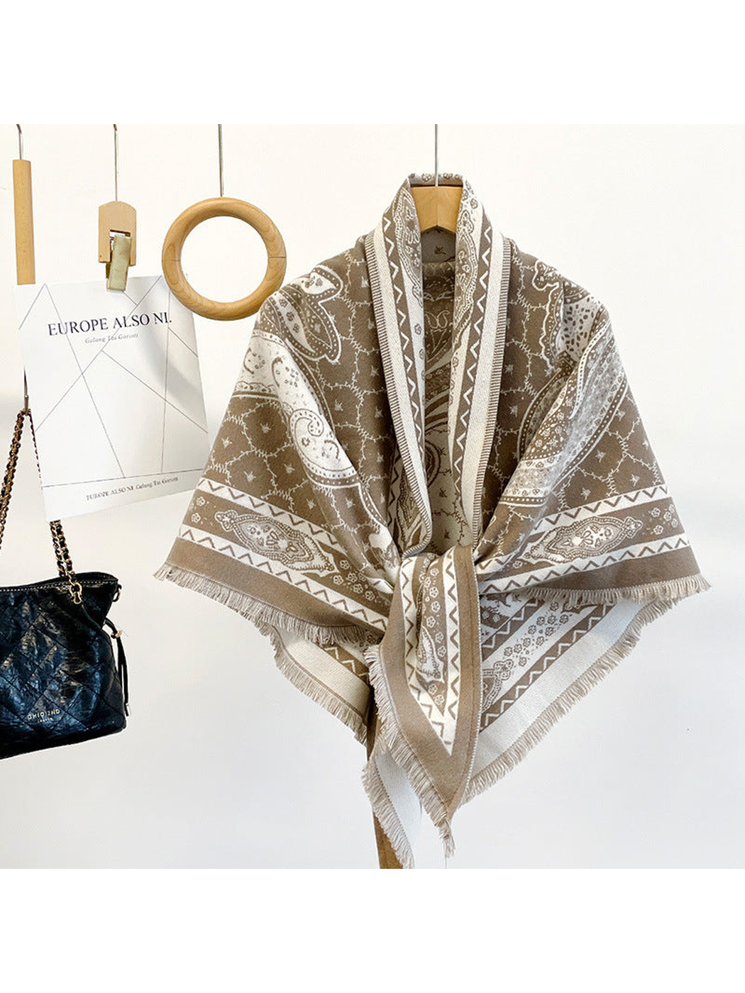 Khaki paisley triangle scarf draped on a hanger