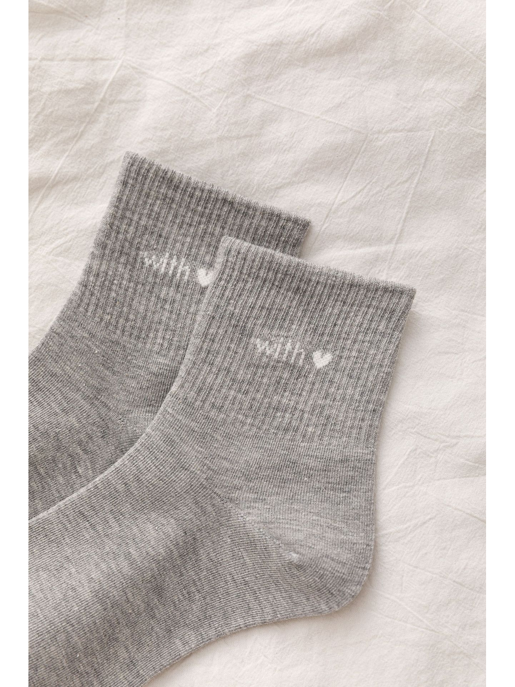 Close-up of gray ribbed cuffs with heart lettering