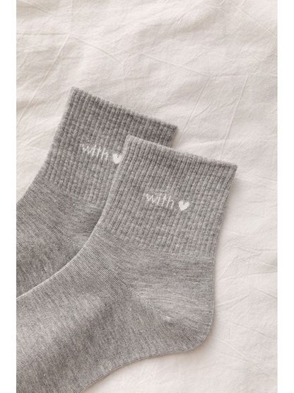 Close-up of gray ribbed cuffs with heart lettering