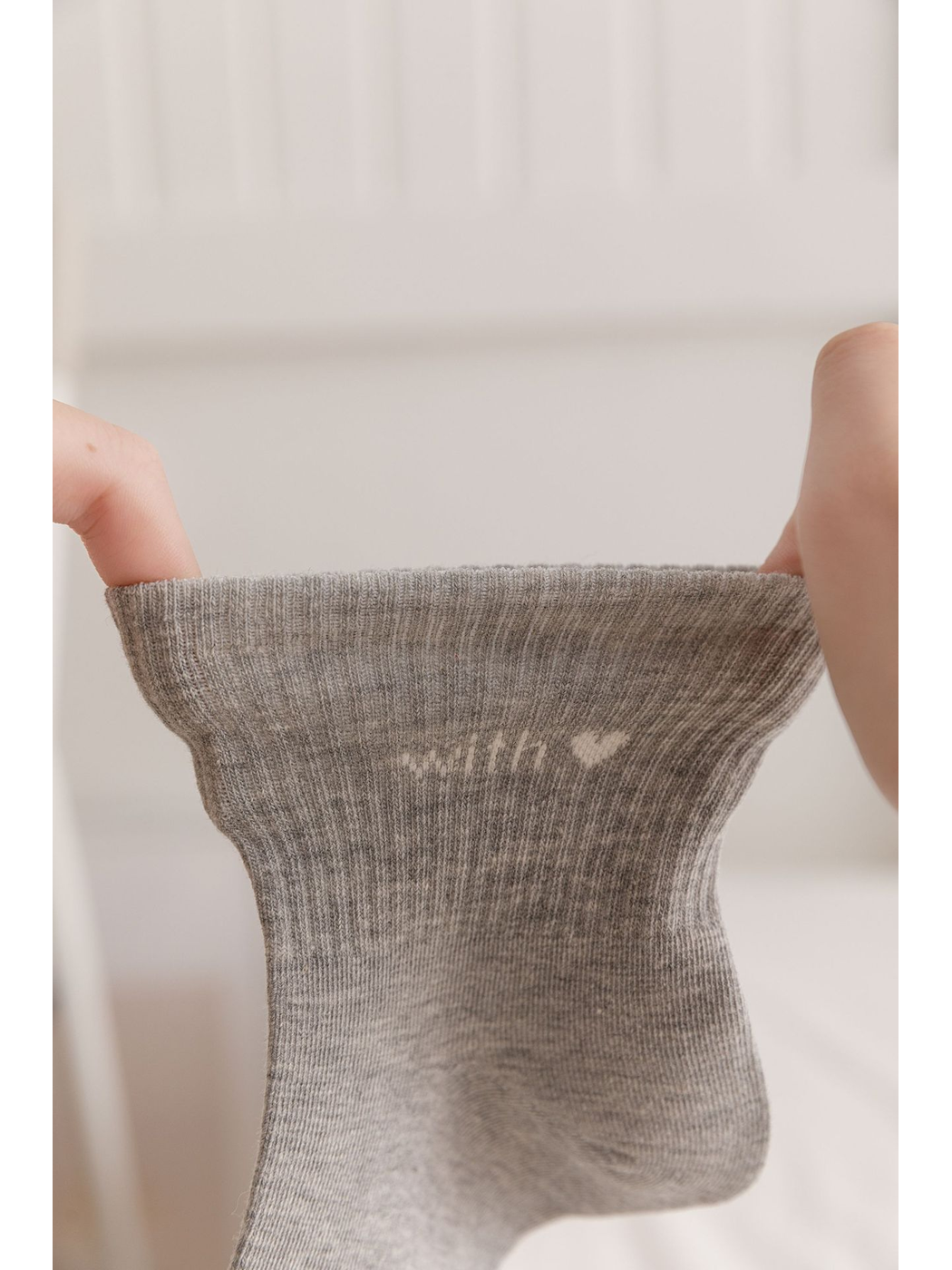 Gray sock cuff stretched between two hands