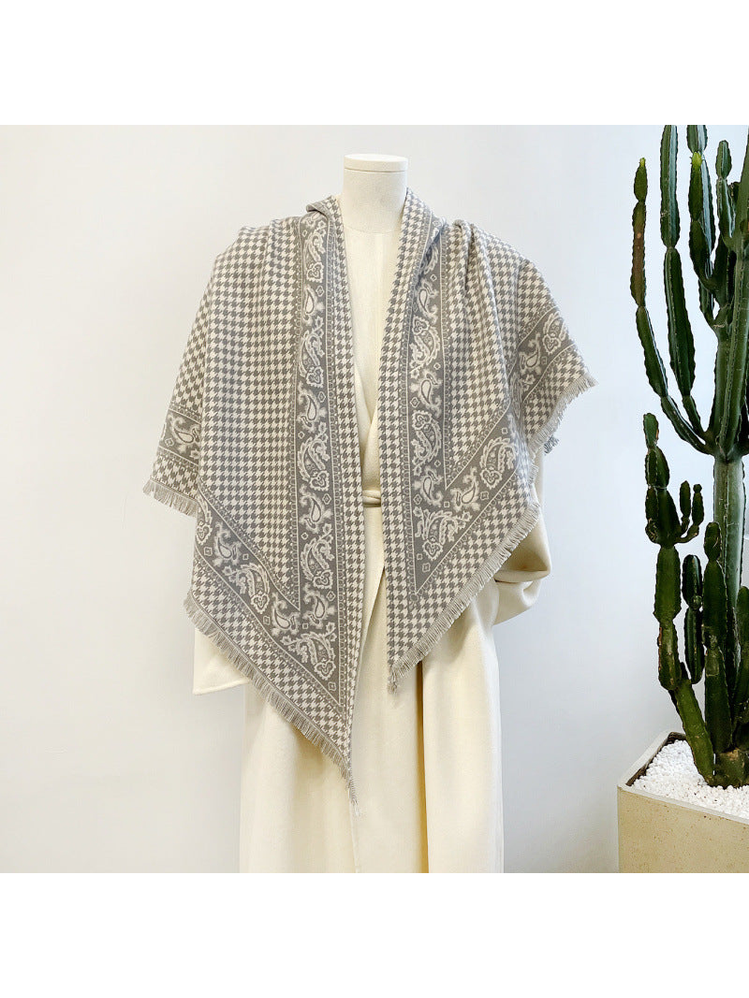 Gray houndstooth and paisley scarf draped over a dress form