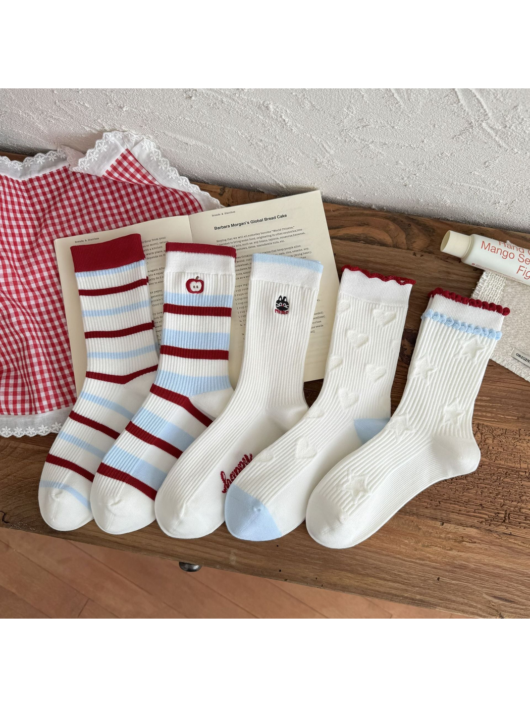 Five white crew sock styles with red and light blue details displayed together