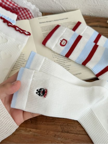 Close-up of Cat and Apple embroidery with striped and raised-motif sock details