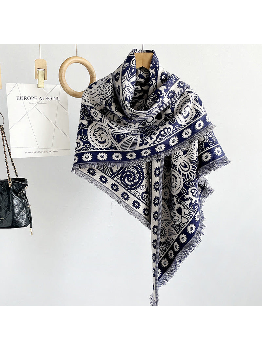 Navy paisley triangle scarf draped on a hanger
