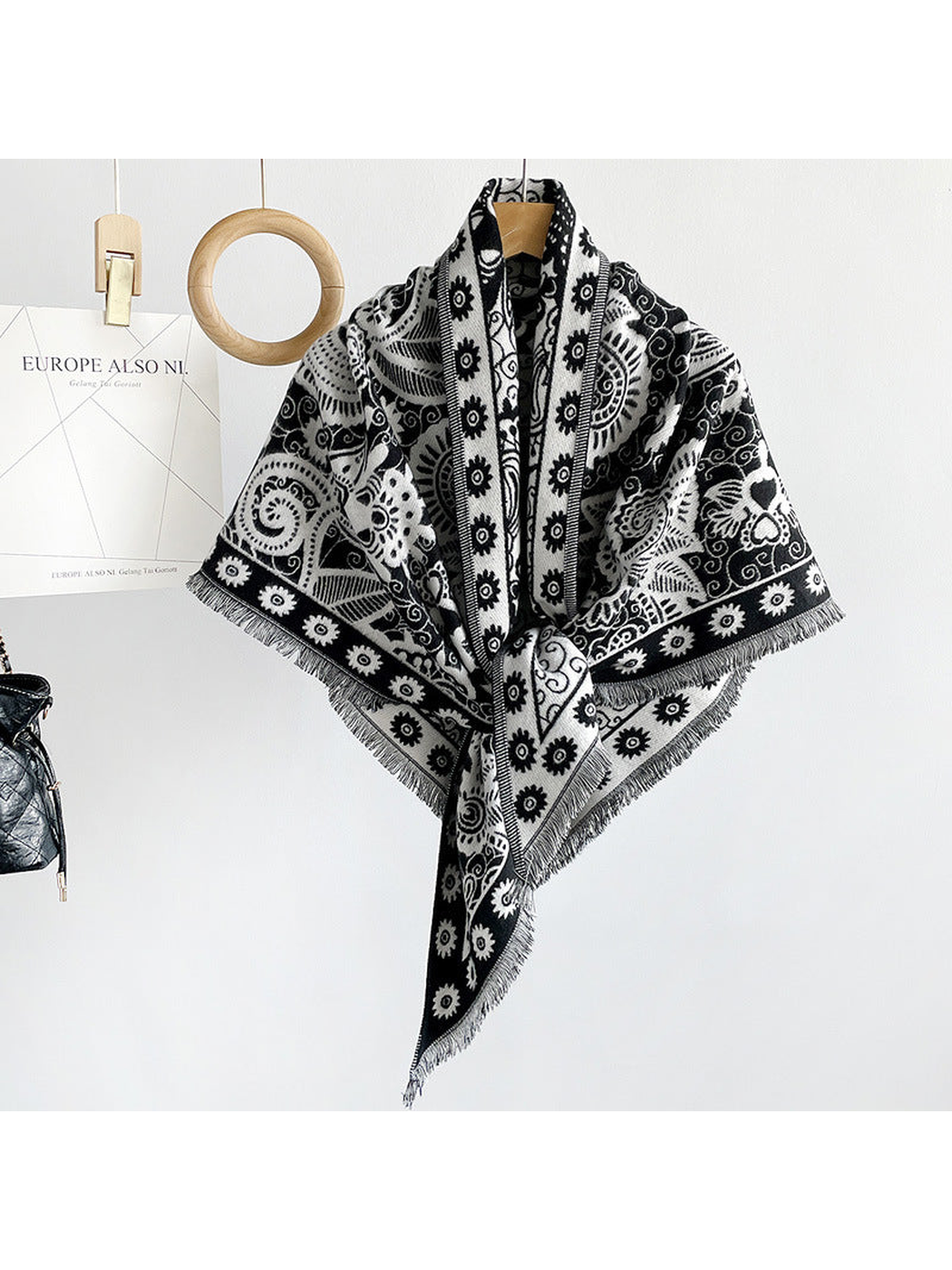Black paisley triangle scarf draped on a hanger