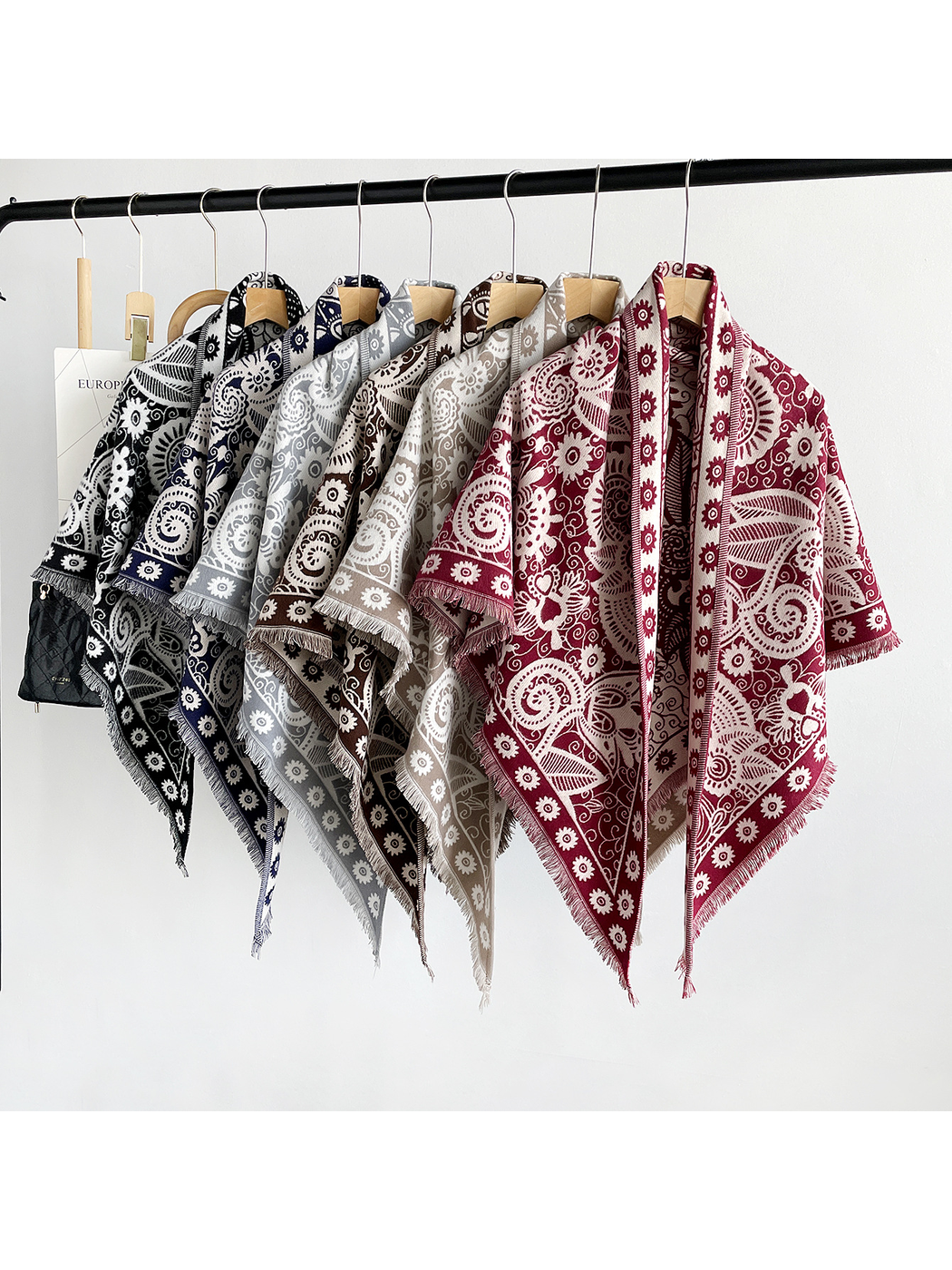 Six paisley triangle scarf colors displayed together on hangers