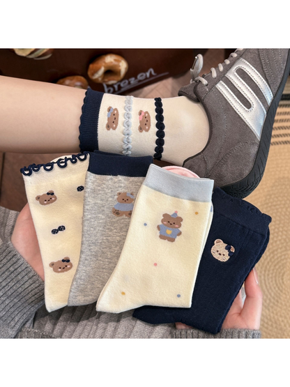 Multiple bear motif sock styles displayed with one style worn with gray sneakers