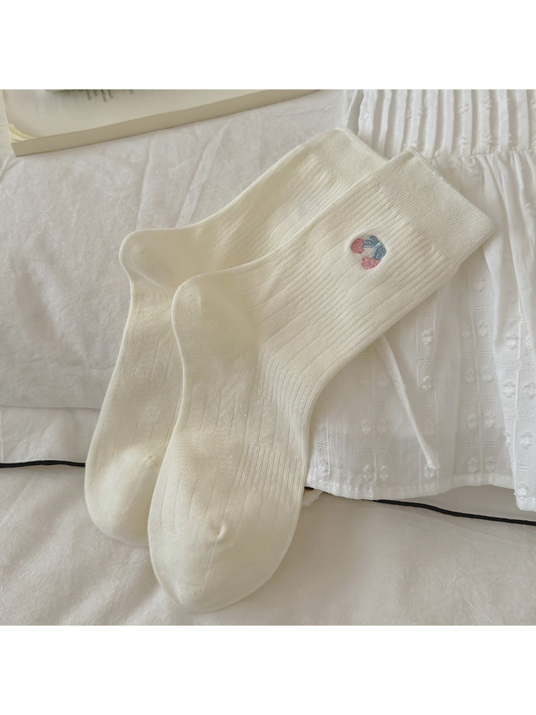 Ivory crew socks with cherry embroidery, laid flat