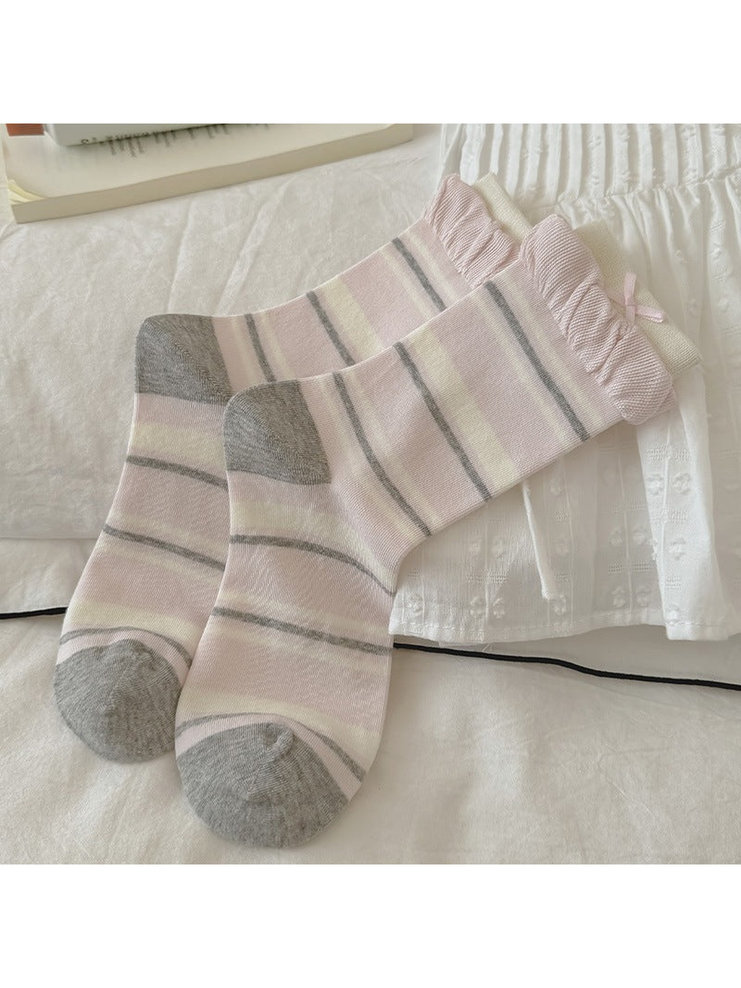 Pink striped crew socks with gray toes and ruffled cuffs, laid flat