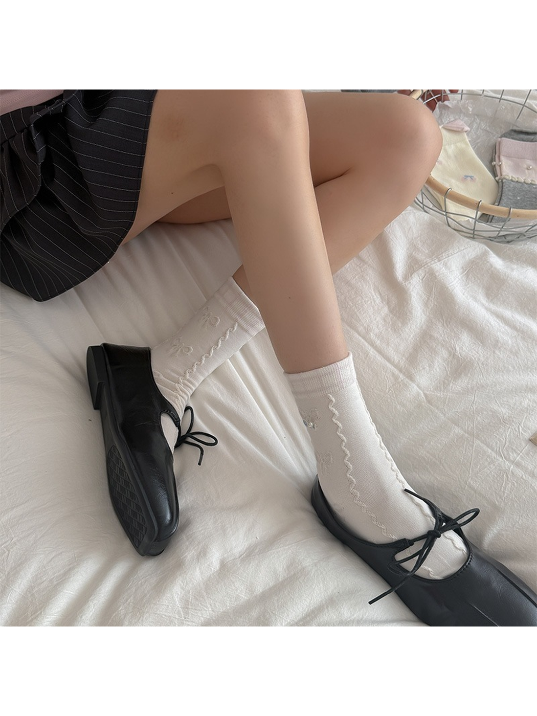 Ivory bow-pattern crew socks worn with black lace-up shoes