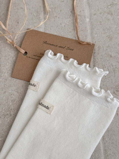 Close-up of White sock ruffle cuffs and small fabric labels