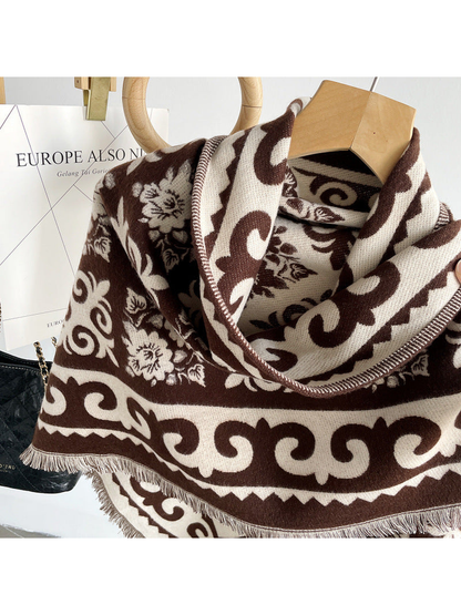 Close-up of the dark brown floral pattern, scrolling border and fringed edge