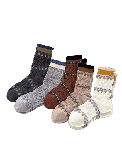 Five colors of patterned crew socks with ruffled cuffs displayed on a white background
