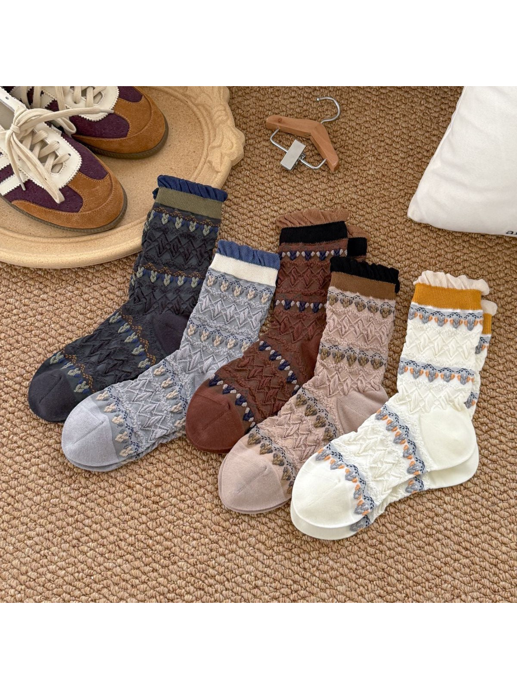 Cream, navy, beige, coffee and light gray patterned crew socks displayed together