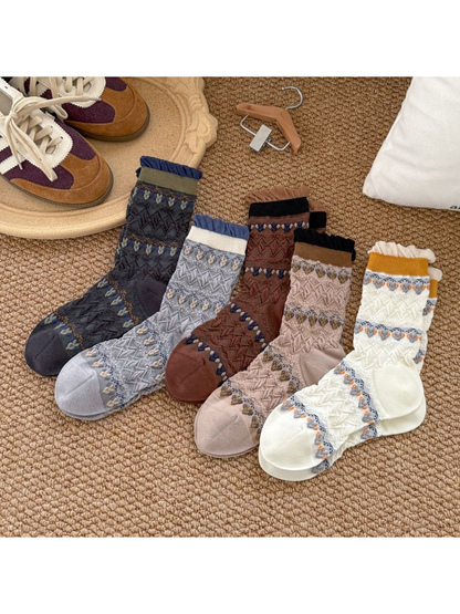 Cream, navy, beige, coffee and light gray patterned crew socks displayed together