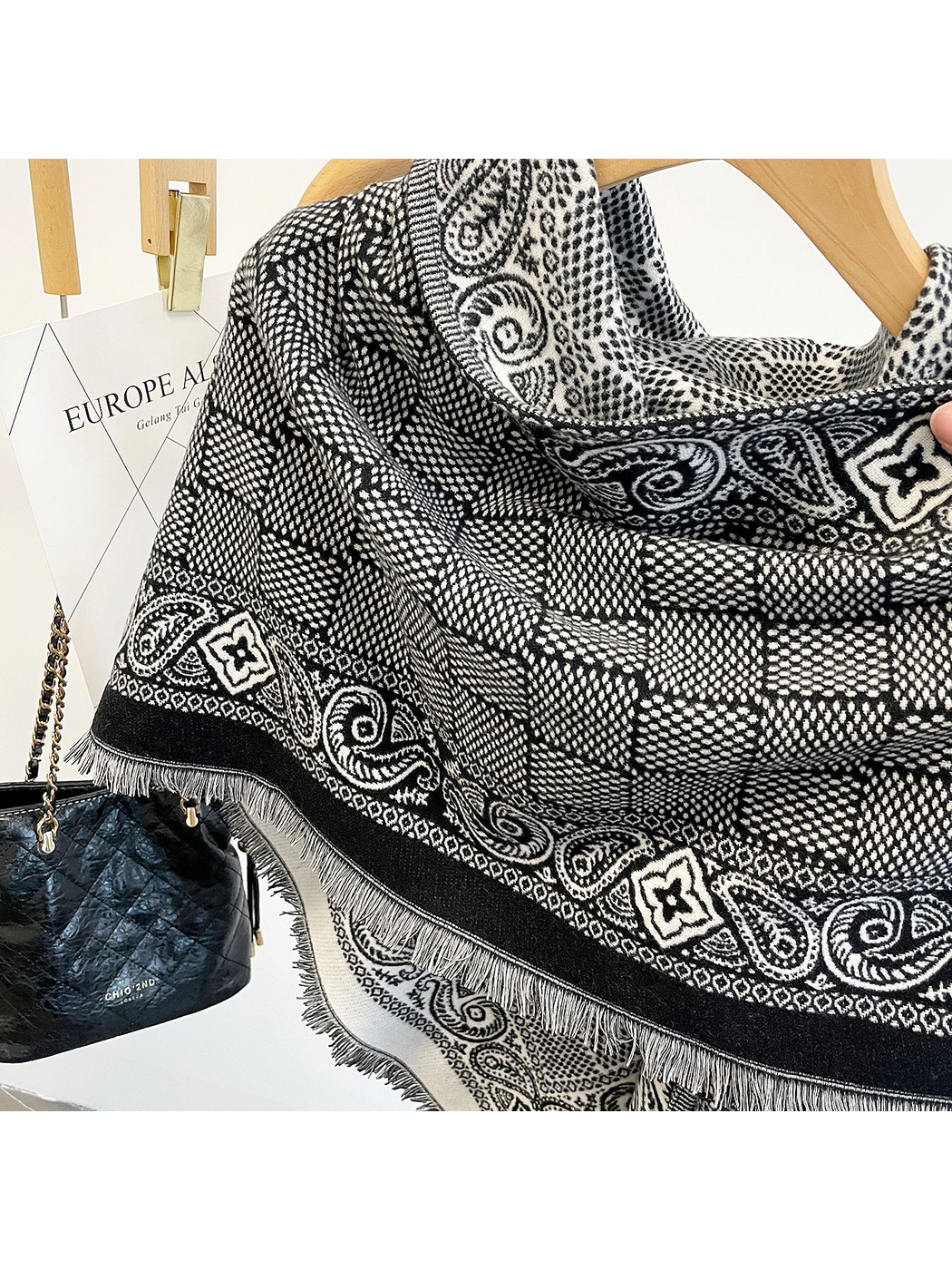 Close-up of the Black scarf's geometric field, paisley border, short fringe and lighter reverse