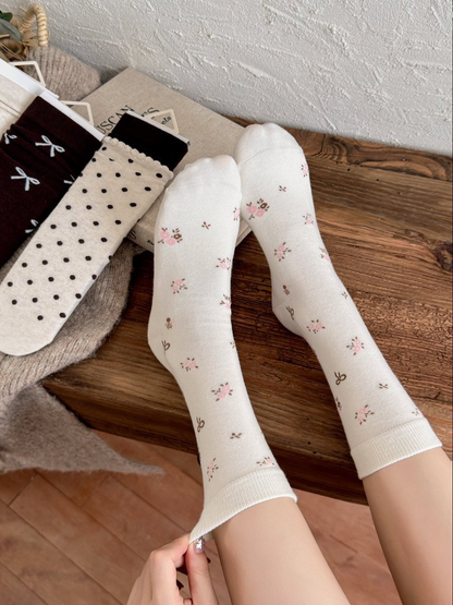 Ivory floral crew socks worn with the full leg-length design visible