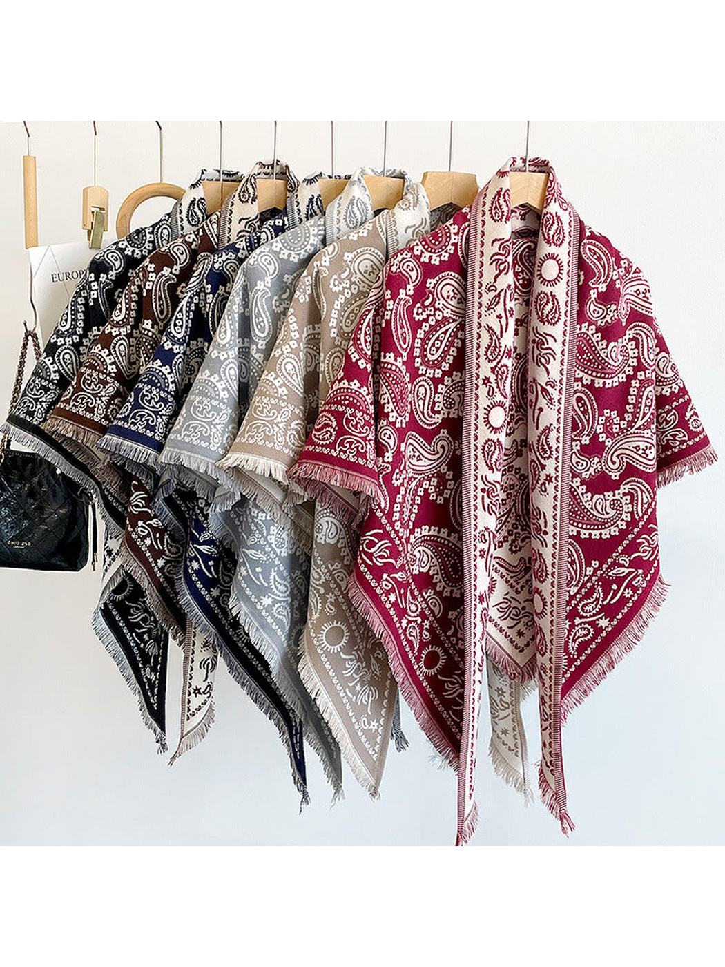 Paisley triangle scarves in multiple colors displayed on hangers