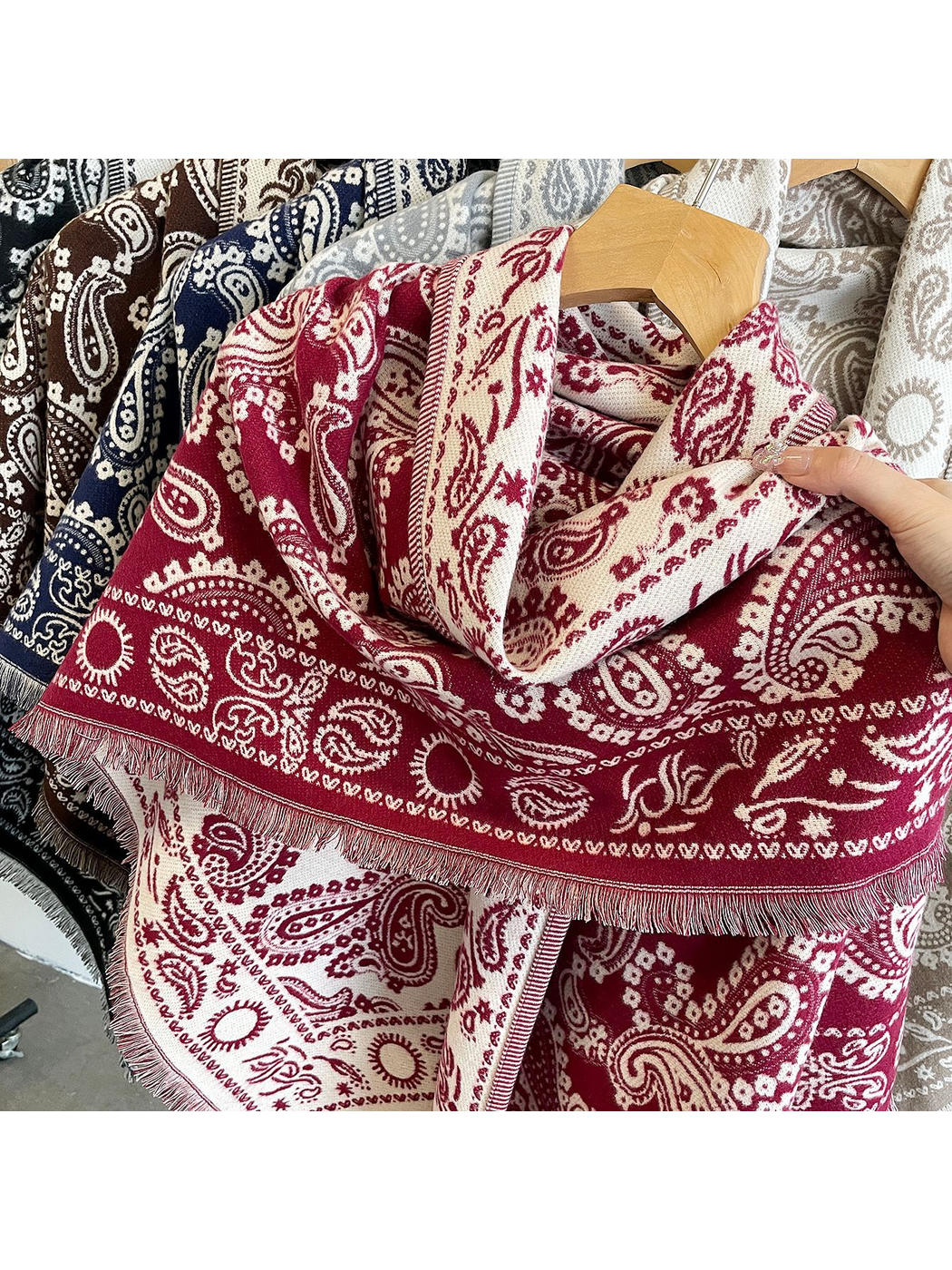 Close-up of the burgundy paisley pattern and short fringed edge