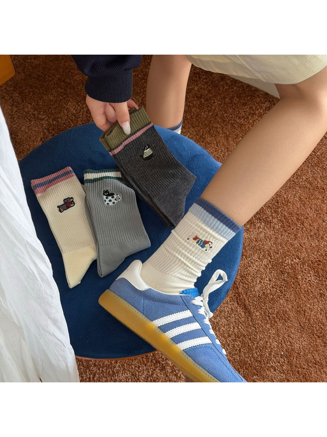 Cream animal motif crew socks worn with blue sneakers