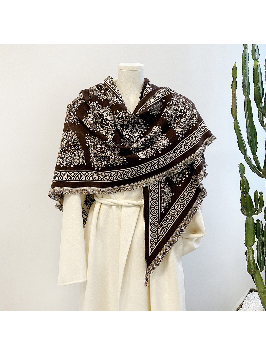 Brown medallion-pattern triangle scarf draped on a mannequin