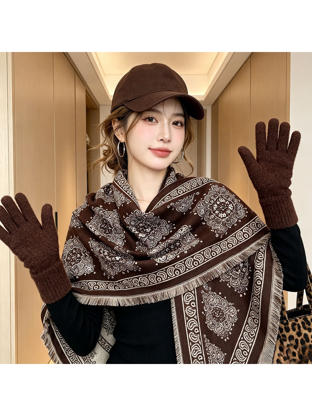 Brown medallion-pattern triangle scarf worn indoors with a dark top