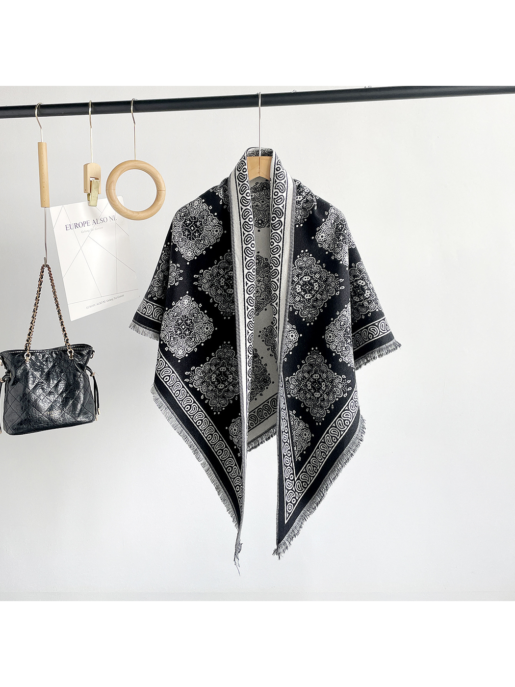 Black medallion-pattern triangle scarf hanging in a full-length front view