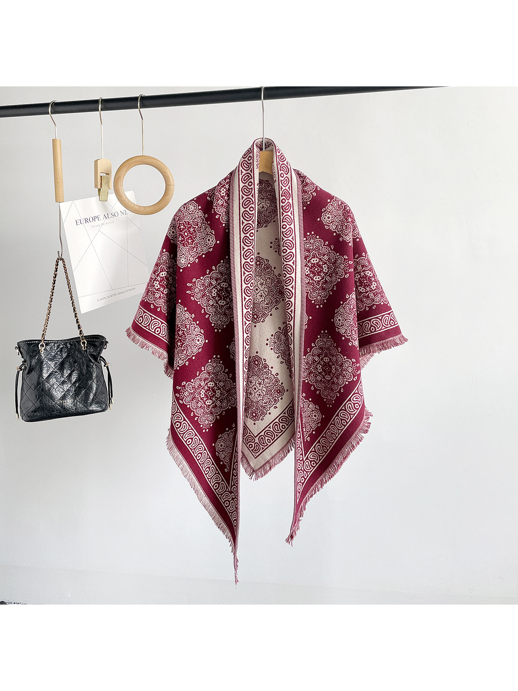 Burgundy medallion-pattern triangle scarf hanging in a full-length front view