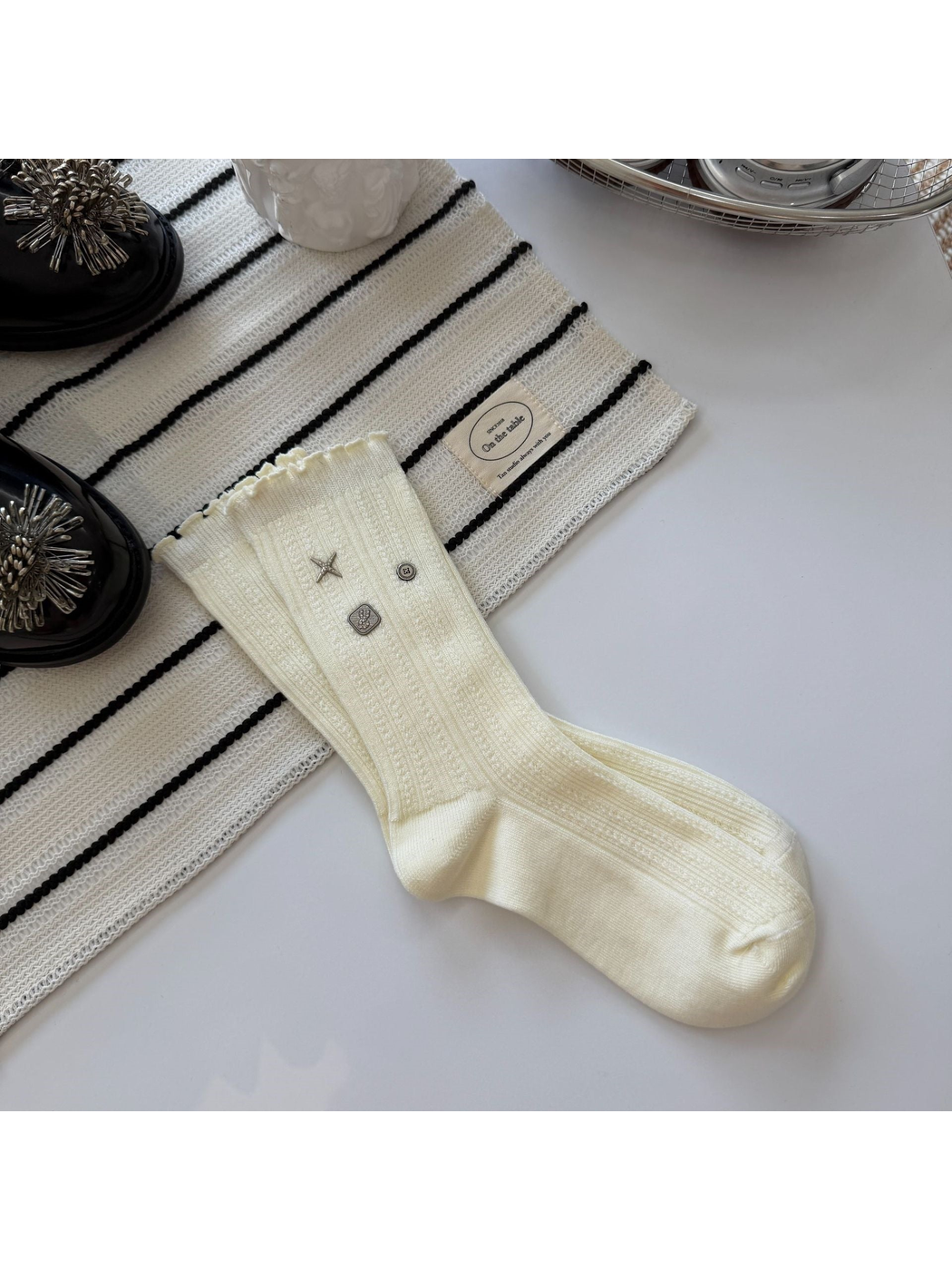 Ivory crew sock with ribbed texture, ruffled cuff and silver-tone accents