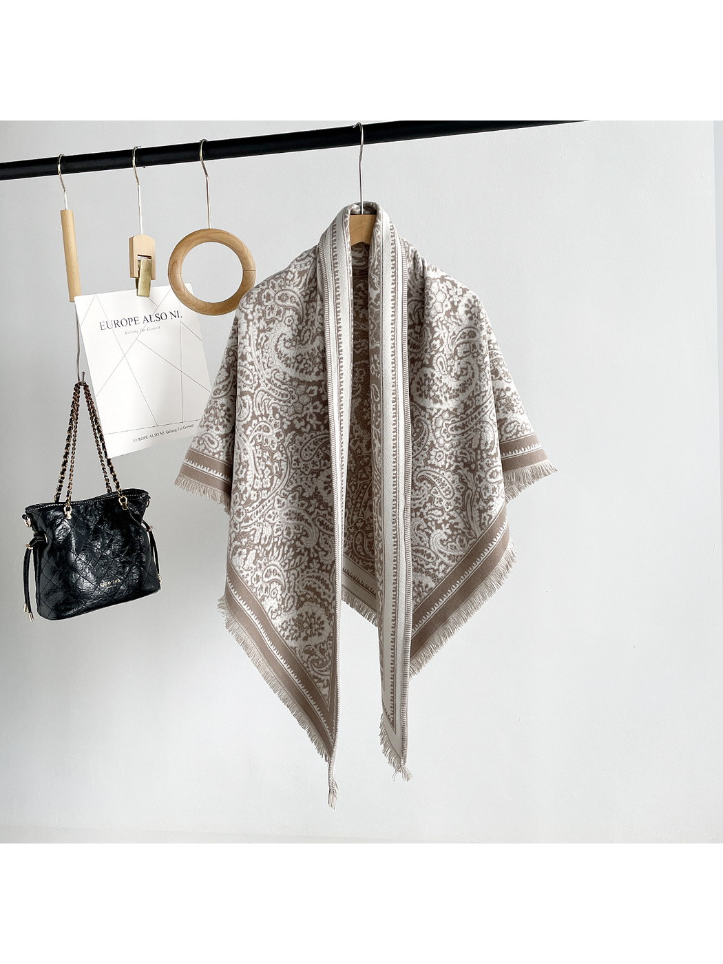 Khaki paisley triangle scarf with contrasting border and short fringe, full hanging view