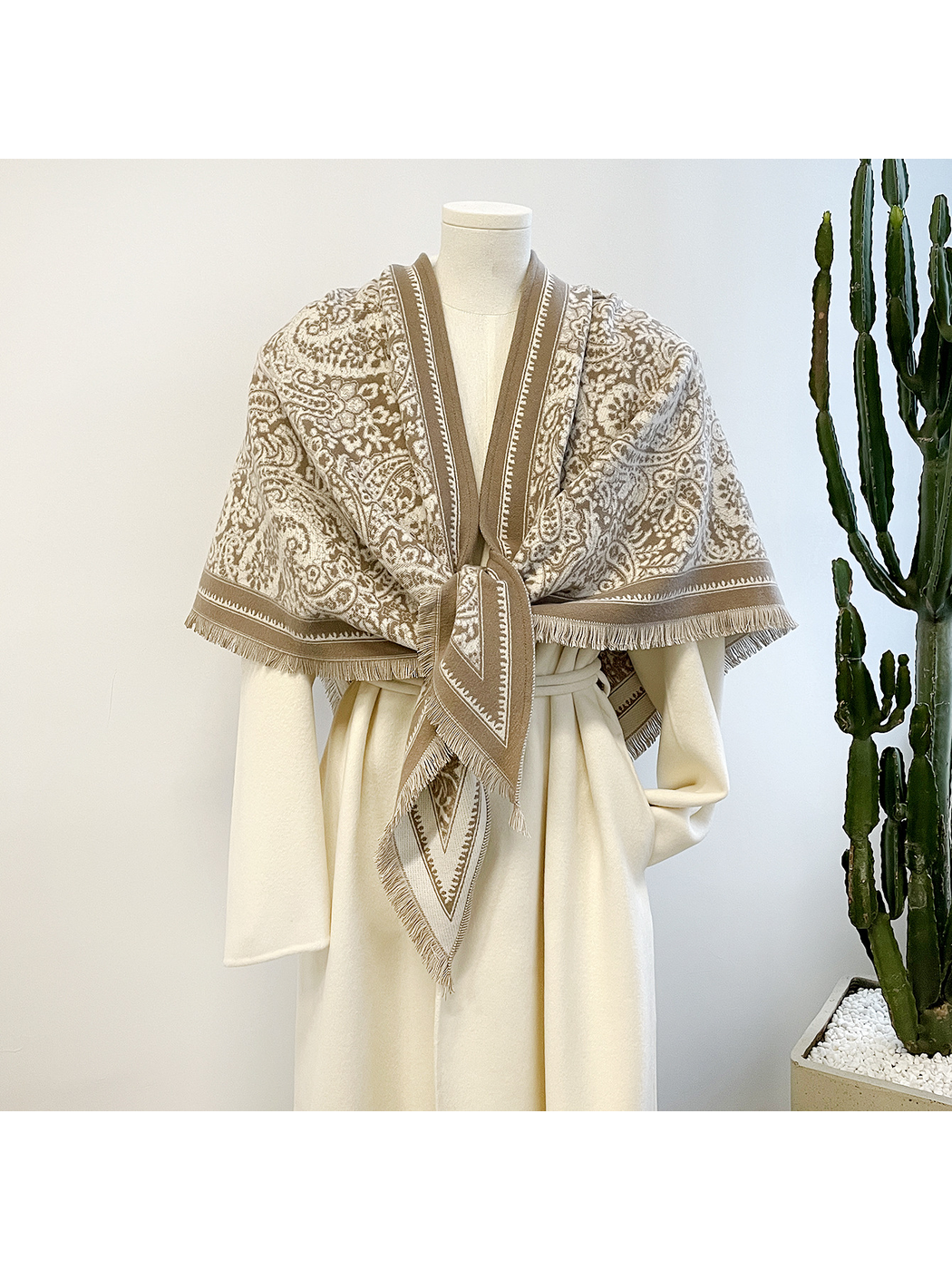 Khaki paisley triangle scarf tied at the front on a mannequin